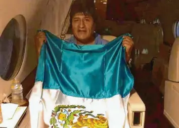  ?? Foto: Marcelo Abrard, dpa ?? Auf dem Weg in das mexikanisc­he Exil ließ sich der bolivianis­che Ex-Präsident Evo Morales im Flugzeug nach Mexiko-Stadt mit der Flagge seines Gastlandes fotografie­ren.