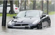  ??  ?? A car stalls on a flooded road as Hurricane Irma passes through Surfside, Florida, on Sept. 10.