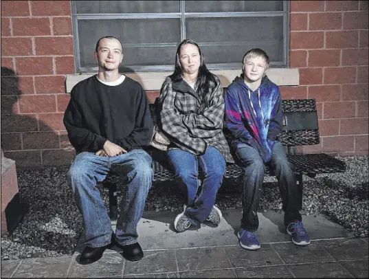  ?? Erik Verduzco Las Vegas Review-Journal ?? Jade Gaastra, left, 23, his mother, Nicole Bayer, and brother Tristan Groom, 15, sit outside the Pahrump Community Library on Feb. 2. Bayer’s sons are former students of Northwest Academy in Amargosa Valley.