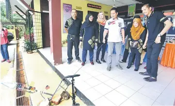  ??  ?? Dr Mohd Faiz (fourth left) prepares to launch a miniature rocket upon arrival at SK Rakyat for the ‘School Attack’ programme organised by P194 Petra Jaya Education Bureau. – Photo by Muhammad Rais Sanusi