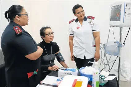  ?? Picture: MARK ANDREWS ?? HEARTENED: Karen Land has her blood sugar checked by nurses Milly McCabe and Phindiwe Moyikwa at St Dominic’s Hospital yesterday