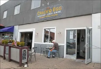  ?? Pittsburgh Post-Gazette ?? A diner eats his meal outside the Crack’d Egg restaurant in Brentwood on Sept. 24.