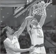  ?? AP-Robert Franklin ?? Georgia Tech’s Jordan Usher (4) dunks over Notre Dame’s Nikola Djogo (13) during the first half Saturday in South Bend, Ind.