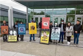  ?? Rachel Swan/The Chronicle ?? Supporters of Maria and Benison Tran hold signs with photograph­s of the slain couple Wednesday outside the East County Hall of Justice in Dublin.