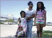  ?? BRIAN MELLEY — THE ASSOCIATED PRESS ?? Tori Texada, 25, Chloe, 7, in right, Maddison, 6, and Paisley, 1, pose for photo outside of the shelter at a convention center in Houston. The single-mother of five, including three who are school-aged, said she wanted to get her kids back to their...