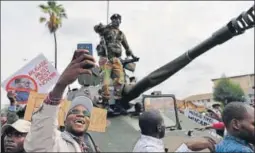  ?? AFP ?? ▪ A man takes a selfie with a Zimbabwean soldier during a march in the streets of Harare.