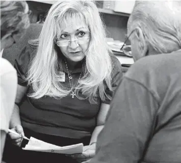  ??  ?? REACHING OUT TO HELP: SNAP outreach worker Dillie Nerios talks to a couple in her Fort Pierce office to see if they qualify for food stamps after losing a great deal of money due to stock downturns, the real estate collapse and medical bills. “This is...