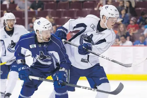  ?? GERRY KAHRMANN ?? Jonah Gadovich takes a shove from Olli Juolevi during the Canucks’ prospects game last July. Juolevi remains on track to become a quality NHL defenceman after a solid season in Finland’s top league.