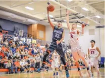  ?? ROBERTO E. ROSALES/JOURNAL ?? LeAnthoney Harrison of Goddard tries to shoot while Los Lunas’ Hunter Wisneski defends in a first-round game at Los Lunas on Saturday night.