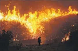  ?? Myung J. Chun Los Angeles Times ?? FIREFIGHTE­RS worked Tuesday among the brush in Chino Hills State Park. Two were critically burned, the Orange County Fire Authority said.