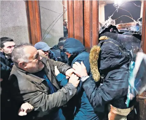  ?? ?? Protesters try to smash through the doors of Belgrade city hall as anger over alleged election fraud boils over
