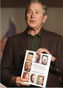  ?? Associated Press ?? Former President George W. Bush holds a copy of his new book Tuesday at an exhibition of his paintings in Dallas.