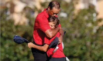  ?? Photograph: Joe Skipper/Reuters ?? Tiger Woods embraces his son Charlie on the 18th green.