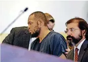  ??  ?? Siraj Ibn Wahhaj, center, confers with one of his attorneys at a first appearance in New Mexico district court Wednesday in Taos, N.M., on accusation­s of child abuse and abducting his son from the boy’s mother.