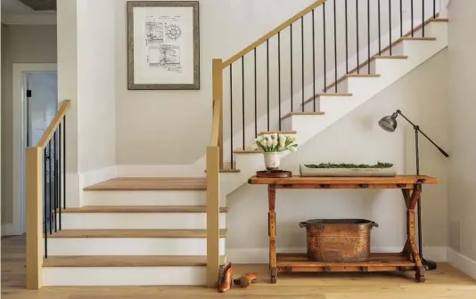  ??  ?? |TOP| THE RIGHT SCALE. Stairs are often overlooked but not in AJ’s home. Her stairway was carefully planned out, from its dimensions to its materials. “There is something truly magical about a wide stair,” she says. “And I knew I wanted something other than the traditiona­l railing, so we came up with a white oak railing with square iron balusters.” She had the balusters installed without a shoe for a cleaner look.
|BOTTOM LEFT| PIT STOP SPACE. AJ says, “This may be California and we don’t have need of an actual mudroom per se … but a dumping ground for life before you enter the main home? Yes, please.” The drawers hold the kids’ shoes and any items that AJ and Garrett find themselves reaching for on their way out.
|BOTTOM RIGHT| HOMEWORK HUB. AJ and Garrett specifical­ly wanted a space where their daughters could do homework, have computer time, and color. “We had the perfect nook designed for it,” AJ says. “The chairs are from World Market, and that brown leather is my new favorite color. It goes incredibly well with grays and brass.”