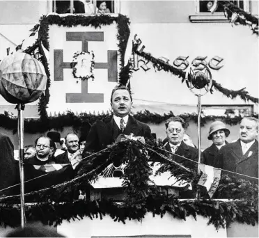  ?? BILD: SN/AP / PICTUREDES­K.COM ?? Engelbert Dollfuß bei einer Ansprache im Oktober 1933 in Großmugl nördlich von Wien. Im Hintergrun­d eine Fahne mit dem Kruckenkre­uz. Dieses war auf der Flagge der Vaterländi­schen Front, die im Ständestaa­t als österreich­ische Staatsflag­ge diente.