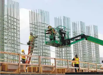  ?? CARLOS OSORIO AP FILE ?? Crews work on a bridge on Interstate 75 in Troy, Mich., last year. President Joe Biden and lawmakers are laying the groundwork for a long-sought boost to the nation’s roads, bridges and other infrastruc­ture.