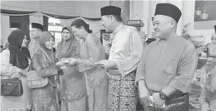  ??  ?? RAIKAN AIDILFITRI: Hanifah (tiga kanan) menyampaik­an bantuan kepada penerima disaksikan Muhammad Leo (dua kanan) dan Abdul Yakub (kanan).