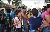  ?? EMILIO ESPEJEL, AP FILE ?? In this July 31, 2019, file photo, migrants line up in Matamoros, Mexico, for a meal donated by volunteers from the U.S., at the foot of the Puerta Mexico bridge that crosses to Brownsvill­e, Texas.