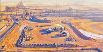  ?? Picture: REUTERS/JIM REGAN ?? A train is loaded near a processing plant at the Fortescue Metals Group (FMG) Christmas Creek iron ore mine located south of Port Hedland in the Pilbara region of Western Australia.