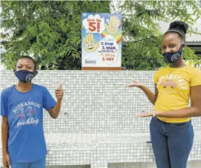  ??  ?? Ocho Rios Primary School students Tajae Brown and Jody-ann Clarke pose by the newly constructe­d handwashin­g station, complete with an instructio­nal sign.