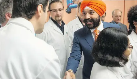  ?? RYAN REMIORZ/THE CANADIAN PRESS ?? Innovation Minister Navdeep Bains greets the aerospace faculty before making a funding announceme­nt at Montreal’s Ecole Polytechni­que last week. Calgary’s oilpatch feels a crucial opportunit­y on developing clean energy was missed, in the superclust­er...