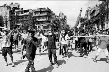  ?? NIRANJAN SHRESTHA/AP ?? Protesters defy a government coronaviru­s lockdown to take part in a religious festival Thursday in Lalitpur, Nepal. The protesters gathered at the site of a 5-story statue of the deity Rato Machindran­ath that’s pulled around the city for a month. Police in riot gear used water cannons and tear gas in the clash. Nepal has logged 257 coronaviru­s deaths.