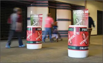  ?? The Sentinel-Record/Mara Kuhn ?? COLLECTION POINTS: Shoppers hurry past food collection bins for Stomp Out Hunger Saturday at Hot Springs Mall.