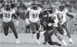  ?? AL DIAZ adiaz@miamiheral­d.com ?? Quarterbac­k Tyler Van Dyke runs for a first down in the first quarter of Saturday’s game against North Carolina State at Hard Rock Stadium.