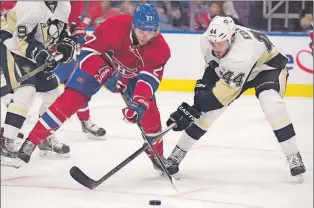  ?? THE CANADIAN PRESS ?? The Montreal Canadiens’ Alex Galchenyuk (left) and the Pittsburgh Penguins’ Tim Erixon chase a puck during the teams’ pre-season game Monday in Quebec City. In an effort to create two scoring lines, the Canadiens are moving the third overall draft pick...