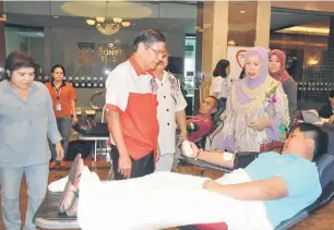  ??  ?? SOKONGAN: Jamilah sambil ditemani Timbalan Pengerusi PBSM Cabang Kuching Dr Chou Chii Ming (dua kiri) melihat secara lebih dekat proses derma darah yang dijalankan.