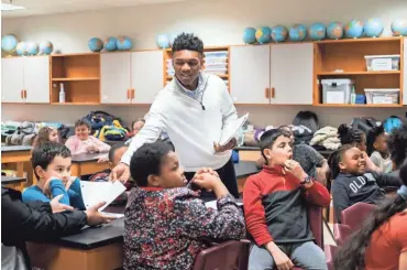  ?? BRANDON DAHLBERG/FOR THE COMMERCIAL APPEAL ?? Collin Siddell, a senior at Houston High School and founder of the nonprofit A Diamond in the Rough, passes out paper to students at Dexter Elementary on Thursday.