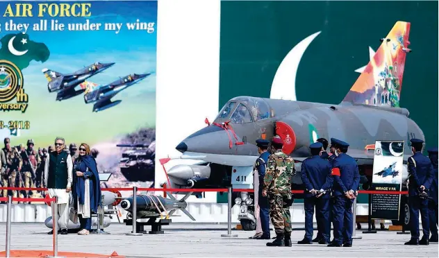  ?? Agence France-presse ?? ↑
President Arif Alvi (left) and his wife Samina Alvi pose for a photograph next to a Pakistan Air Force fighter aircraft in Shorkot on Thursday.