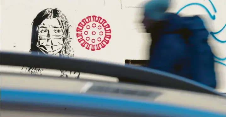  ?? Foto: Jörg Carstensen, dpa ?? Das neue Virus kommt: Was dieses Streetart‰Kunstwerk im Berliner Kiez Prenzlauer Berg zeigt, fürchten Bürger, Politik und Mediziner auch in der Realität.