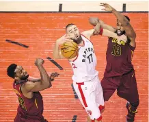  ??  ?? Jonas Valanciuna­s, middle, and the Toronto Raptors fought hard but still lost in overtime Tuesday in Game 1 against the Cleveland Cavaliers.