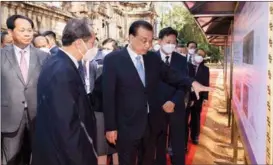  ?? HUANG JINGWEN / XINHUA ?? Premier Li Keqiang (center) and Cambodian Deputy Prime Minister Chea Sophara (left) visit an exhibition on achievemen­ts in ChinaCambo­dia cultural heritage exchanges and cooperatio­n, in Siem Reap, Cambodia, on Nov 10.