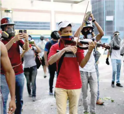  ?? |CORTESÍA ?? El músico venezolano se hizo famoso por salir a tocar su instrument­o a la calle en medio de las protestas y las bombas lacrimógen­as en Caracas.