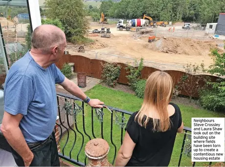  ?? ?? Neighbours Steve Crossley and Laura Shaw look out on the building site where fields have been torn up to create a contentiou­s new housing estate