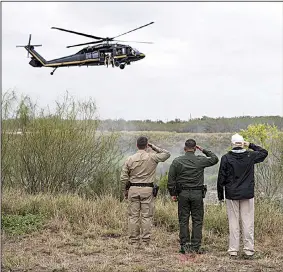  ?? The New York Times/DOUG MILLS ?? President Donald Trump (top, right) salutes a U.S. Customs and Border Protection helicopter Thursday as it flies over the Rio Grande during Trump’s visit to the border town of McAllen, Texas. Trump met with Border Patrol officers and heard stories of violent deaths at the hands of people in the country illegally. Protesters were in the streets of McAllen (left) as Trump visited, while back in Washington lawmakers sought an agreement to end the government shutdown.