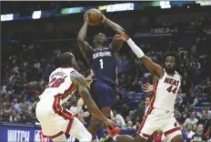  ?? ASSOCIATED PRESS ?? IN THIS MARCH 6 FILE PHOTO, New Orleans Pelicans forward Zion Williamson (1) goes up for a basket as Miami Heat guard Andre Iguodala (28) and forward Solomon Hill (44) defend during the second half of a game in New Orleans.