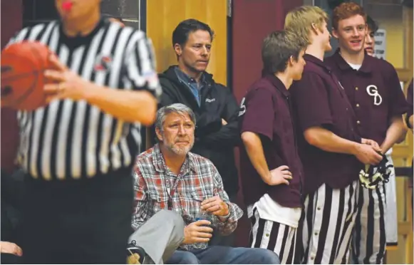  ?? Photos by John Leyba, The Denver Post ?? Ex-golden boys basketball coach John Anderson attends a game against Evergreen last month, sitting near some of his former players. Anderson resigned from his position just before Christmas break amid accusation­s of verbal and physical abuse of the...