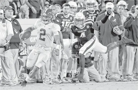  ?? David J. Phillip / Associated Press ?? Alabama quarterbac­k Jalen Hurts, left, rushes for a first down as Texas A&M defensive back Derrick Tucker gives chase during the second quarter Saturday night.