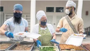  ?? RAMSAY DE GIVE THE NEW YORK TIMES ?? Volunteers at the Hacienda de Guru Ram Das strictly abide by COVID-19 guidelines, wearing masks and gloves while preparing and handing out meals in Sombrillo, N.M.