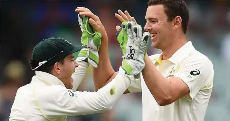  ?? Photos: Getty Images ?? SEE IT IN 4K: Tim Paine (left) and Josh Hazlewood of Australia celebrate the wicket of Mohammed Shami of India during day two of the First Test.