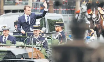  ??  ?? Macron waves from a command car on the Champs Elysees avenue. — Reuters photo