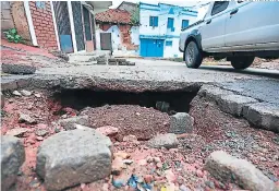  ?? FOTO: DAVID ROMERO ?? la inclinació­n de la estrecha calle y el enorme agujero diecultan la conducción, ror eso los vecinos solicitan su reraración.