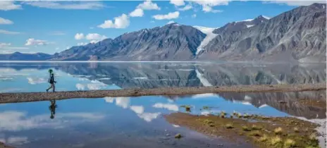  ?? RYAN BRAY/THE CANADIAN PRESS ?? A Parks Canada staff member hikes near Tanquary Fiord with a Google trekker camera in Quttinirpa­aq National Park in Nunavut.