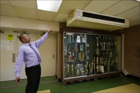  ?? ROGELIO V. SOLIS — THE ASSOCIATED PRESS ?? Jim Hill High School principal Bobby Brown points out one of the outdated air conditioni­ng units that are installed throughout the Jackson, Miss., school Jan. 12. A litany of infrastruc­ture issues in the nearly 60-year-old school make for tough choices on spending COVID recovery funds on infrastruc­ture or academics.