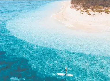  ??  ?? ULTIMATE HOLIDAY: You could be stand-up paddle boarding around Wilson Island.
Picture: Katie Purling, Tourism and Events Queensland