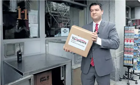  ?? FRED CHARTRAND/THE CANADIAN PRESS ?? The Canadian Taxpayers Federation’s Federal Director Aaron Wudrick delivers a petition to the Prime Minister’s Office, signed by more than 133,000 Canadians opposing the government’s decision to pay Omar Khadr a settlement near Parliament Hill, in...